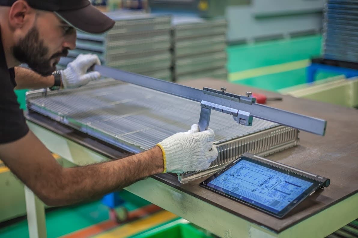 Automoty engineer measuring a radiator core against the CAD reference on a tablet